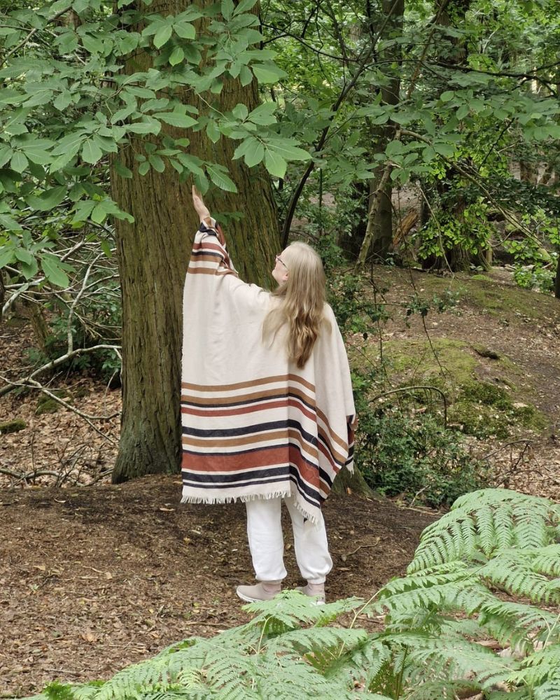About-Johanna_Soie_800x1000 Johanna standing in a forest reaching up toward tree leaves, representing connection with nature and mindful awareness
