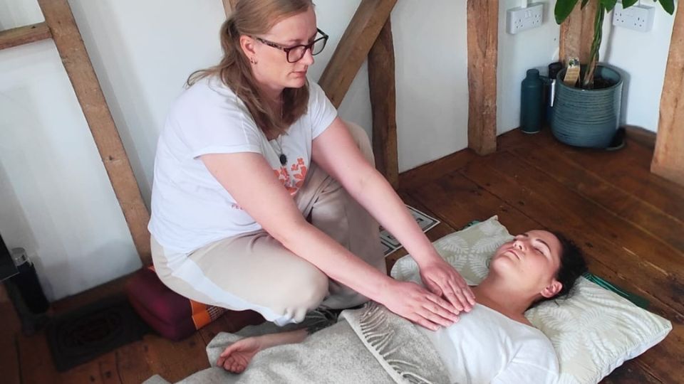 Soie-work-with-me-Shamanic-Energy-Healing Johanna placing hands on a person’s chest during a healing session, representing relaxation and energetic support