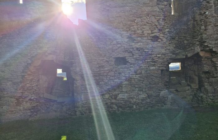 SOIE-shining-light Sunlight streaming through openings in an old stone wall, representing bringing hidden aspects into awareness and transformation